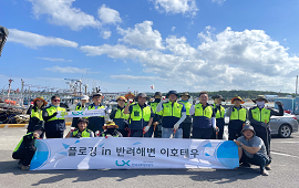 주황색 조끼를 입은 사람들이 밭에서 농작업을 도우며 일손 돕기 활동을 하는 모습