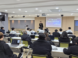 강사가 프레젠테이션을 진행하고 수강생들이 교육 내용을 듣고 있는 강의실 모습